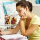 Unhappy Teenage Girl Studying At Desk In Bedroom Looking At Mobile Phone